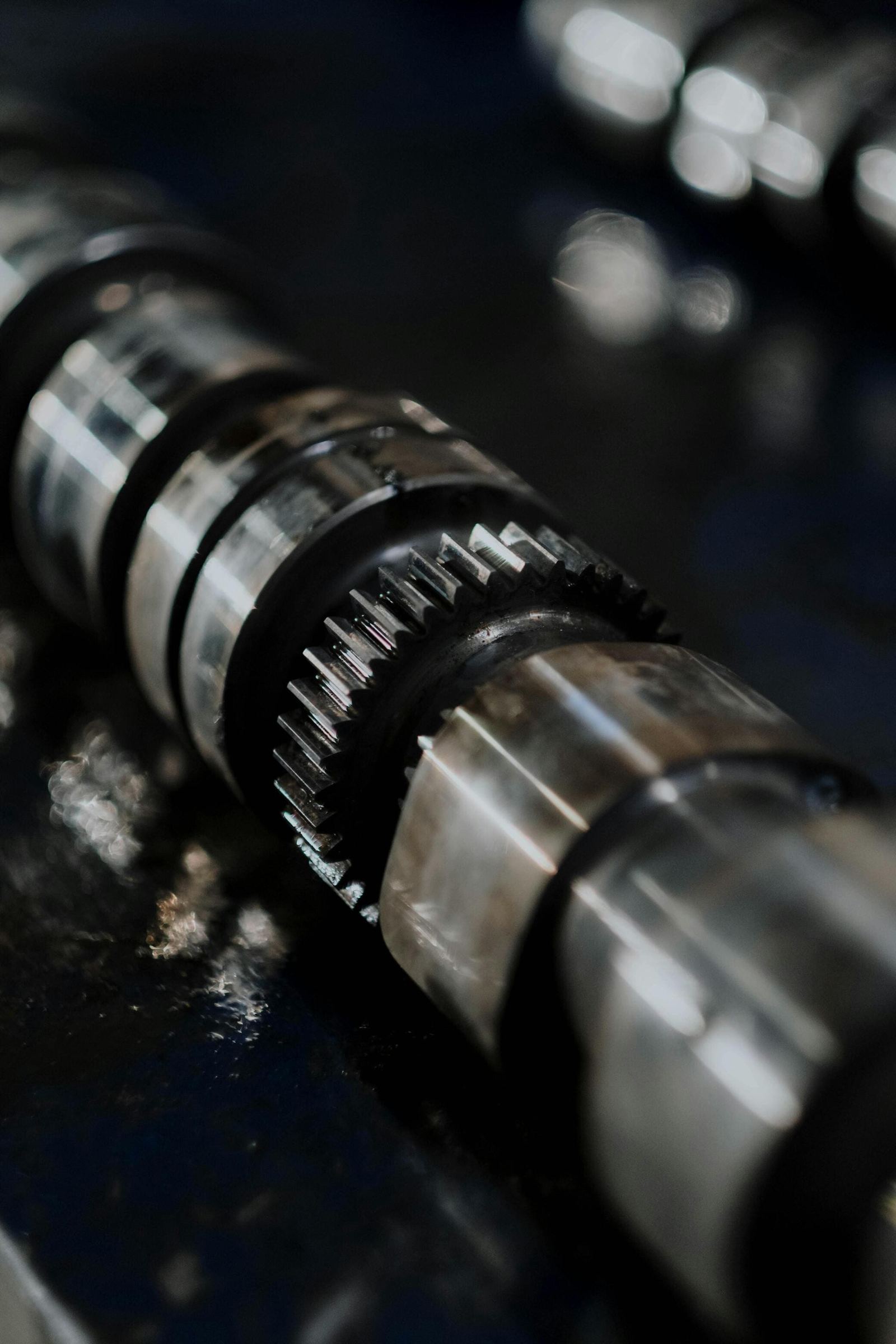 Precision-ground camshaft on a machine shop bench